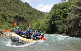Rafting cerca de Benasque en el río Ésera con familias disfrutando de una actividad de aventura.