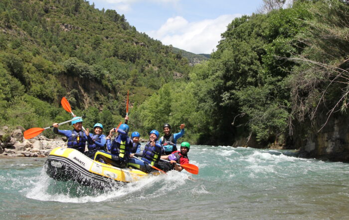 Rafting cerca de Benasque en el río Ésera con familias disfrutando de una actividad de aventura.